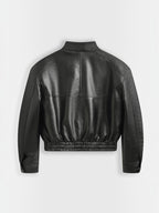 Back view of a black Copperose faux leather cropped jacket with a stand collar and elasticated hem by BROCK