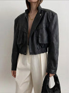 BROCK Copperose black faux leather cropped jacket with structured shoulders, mandarin collar, and flap pockets.