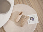 BROCK ERYNN beige cocooning ankle boots with geometric trim and thick cushioned soles on a round rug