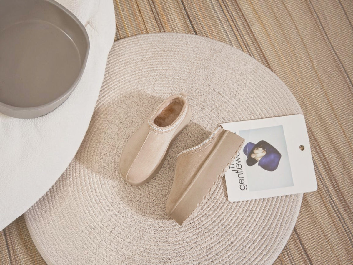 BROCK ERYNN beige cocooning ankle boots with geometric trim and thick cushioned soles on a round rug