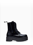 BROCK ERYNN black patent combat boots with platform lug sole, lace-up front, and white contrast stitching.