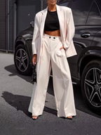 BROCK ESTEES two-piece set featuring a white oversized blazer and wide-leg trousers worn with a black crop top