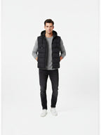 BROCK FIVE EVER black quilted hooded vest worn by a man with a grey sweater and black jeans