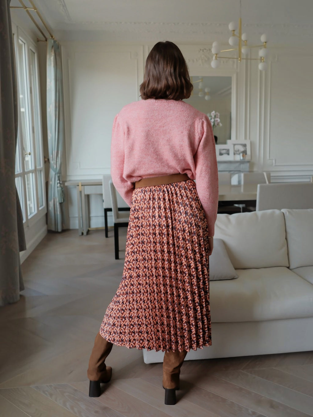 BROCK long pleated skirt with geometric print and satin finish worn with a pink sweater and brown boots