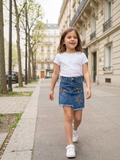 BROCK girl wearing a blue denim skirt with leopard print bow details and a frayed hem walking on a city street.