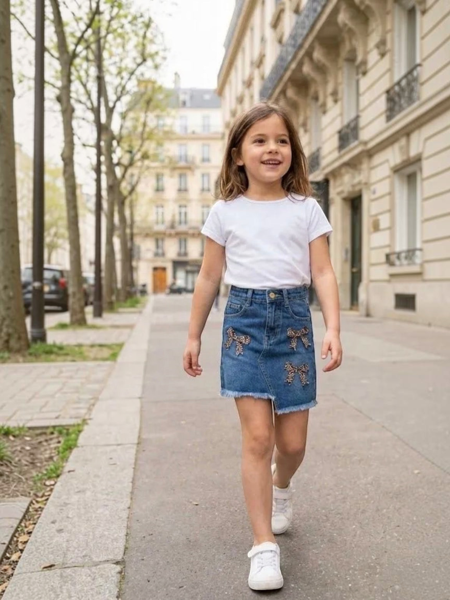 BROCK girl wearing a blue denim skirt with leopard print bow details and a frayed hem walking on a city street.