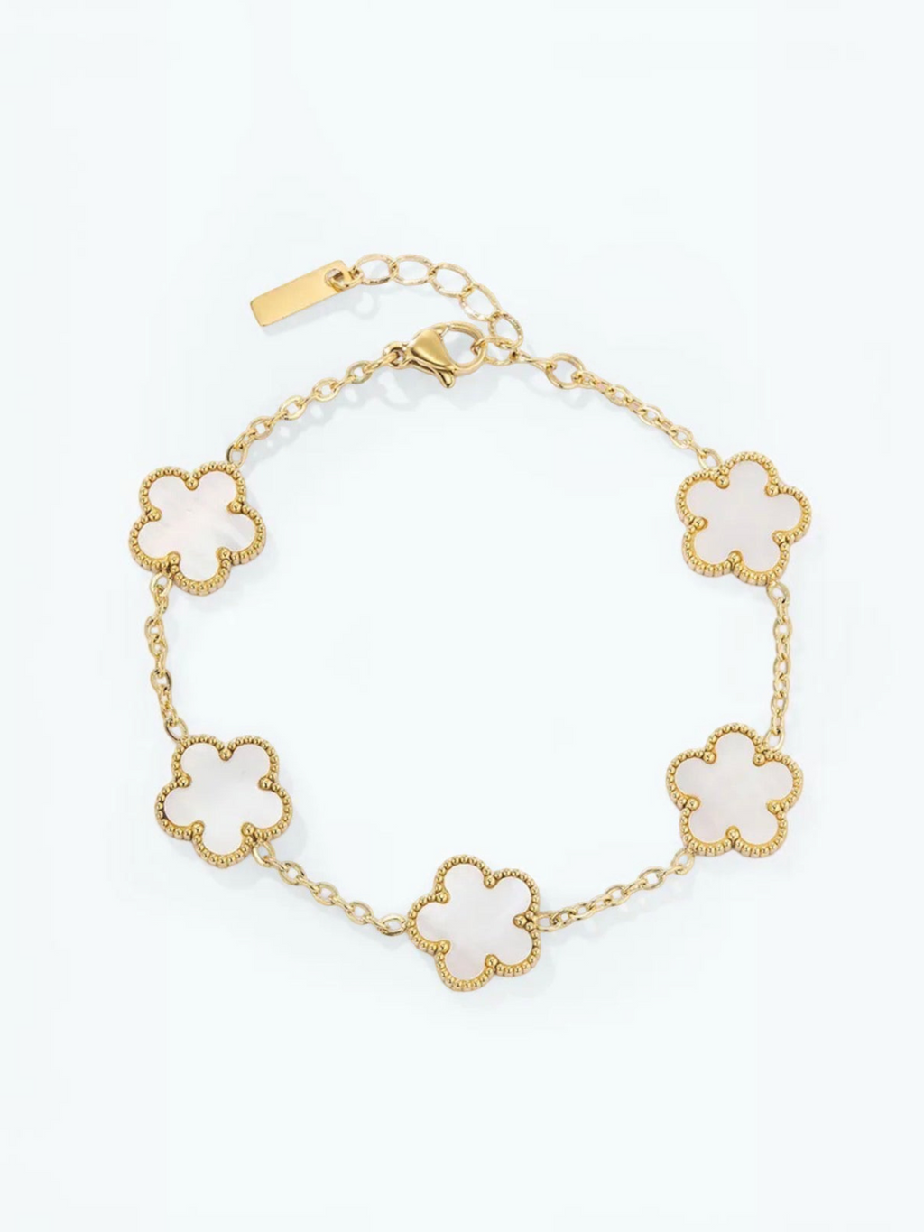 BROCK gold-tone stainless steel bracelet featuring five white flower-shaped charms with beaded edges