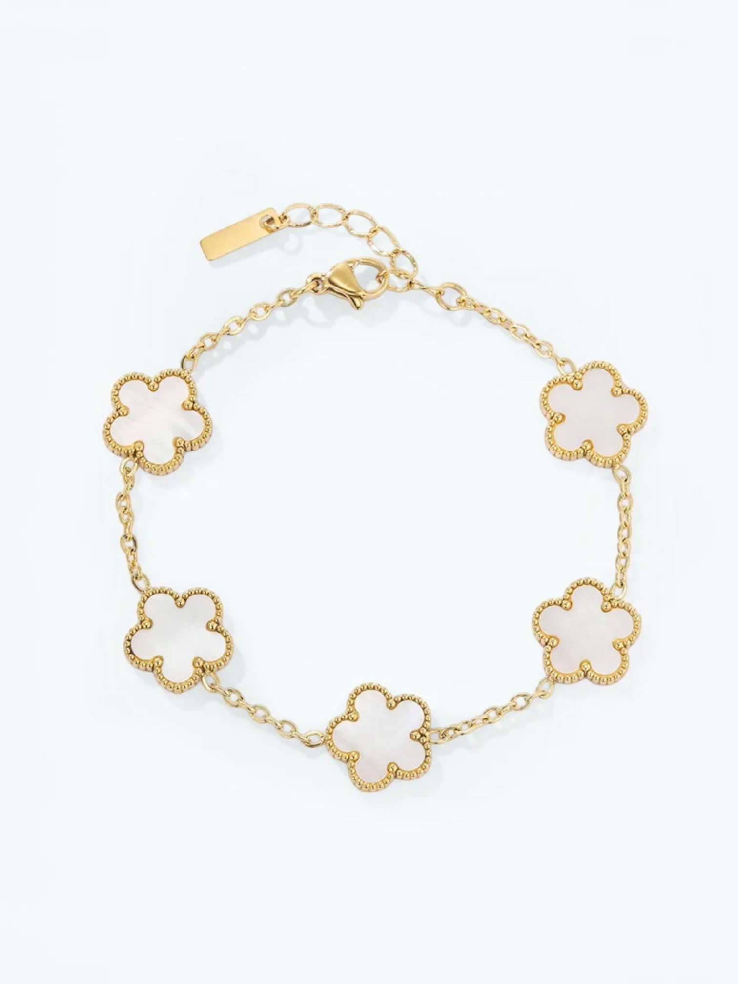 BROCK gold-tone stainless steel bracelet featuring five white flower-shaped charms with beaded edges