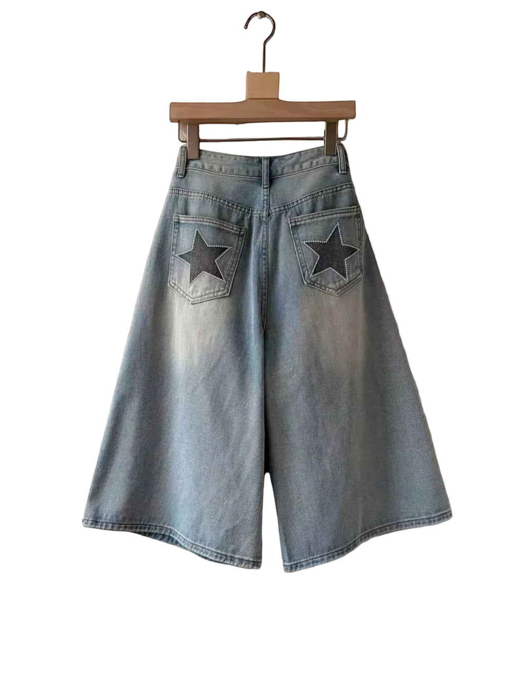 BROCK Golden Days high-waisted denim skort in light wash cotton with star-detailed back pockets on a hanger