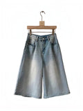 BROCK Golden Days high-waisted light wash denim skort with flared cut and stitched details on a wooden hanger