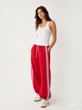 Model wearing BROCK Golden days wide-leg red viscose trousers with white side stripes and adjustable leg cuffs