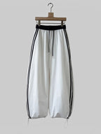 BROCK Golden days wide-leg viscose trousers in white with black side stripes, elastic waist, and adjustable cuffs.