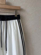 BROCK Golden days wide-leg trousers in white viscose with black side stripes and an elastic drawstring waist.