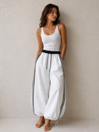 BROCK Golden days wide-leg viscose trousers in white with black side stripes, elastic waist, and adjustable cuffs.