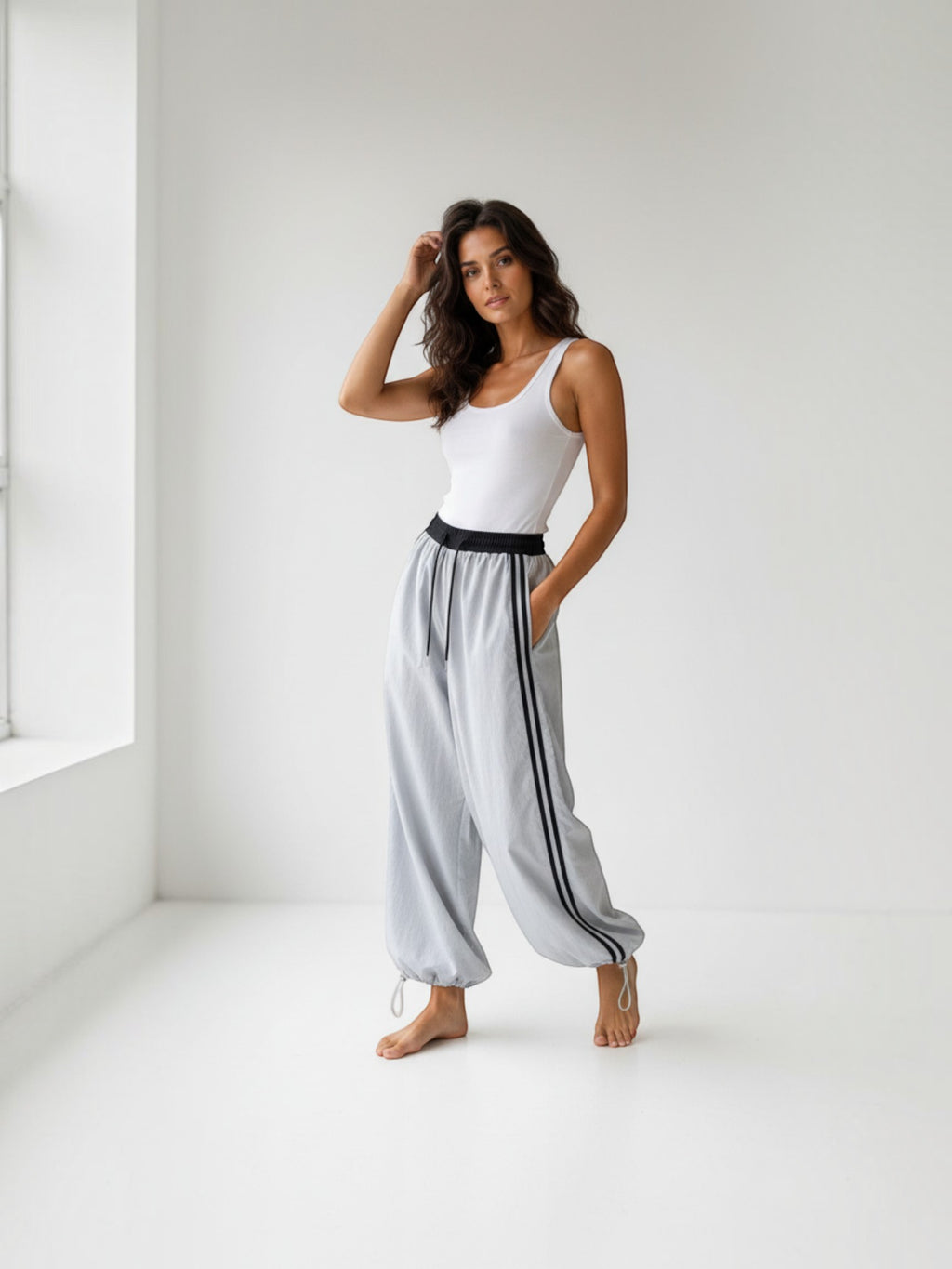 Model wearing BROCK Golden days wide-leg viscose trousers in light grey with black side stripes and adjustable hems