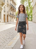 BROCK GRASSTAR girl's black denim skirt with leopard print bow details and frayed hem worn by a smiling child