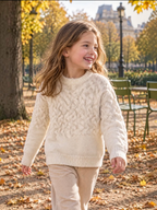 BROCK GRASSTAR cream cable-knit sweater with round neck worn by a smiling girl in an autumn park
