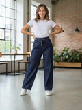 BROCK GRASSTAR dark blue denim jeans with an elastic waistband and drawstring worn by a woman in a bright studio