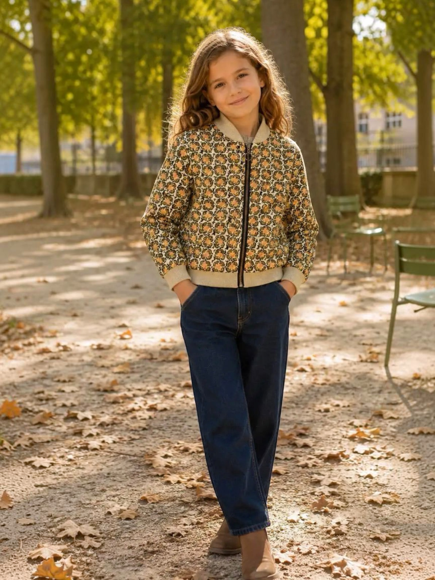 Young girl wearing a patterned BROCK GRASSTAR bomber jacket with a zip front in a park setting