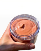BROCK GUAPA white musk sugar body scrub in a clear jar with a creamy pink exfoliating texture