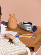 BROCK HINDBAG Mia tricolore sage green round pencil case on a wooden desk with a rabbit lamp and pens