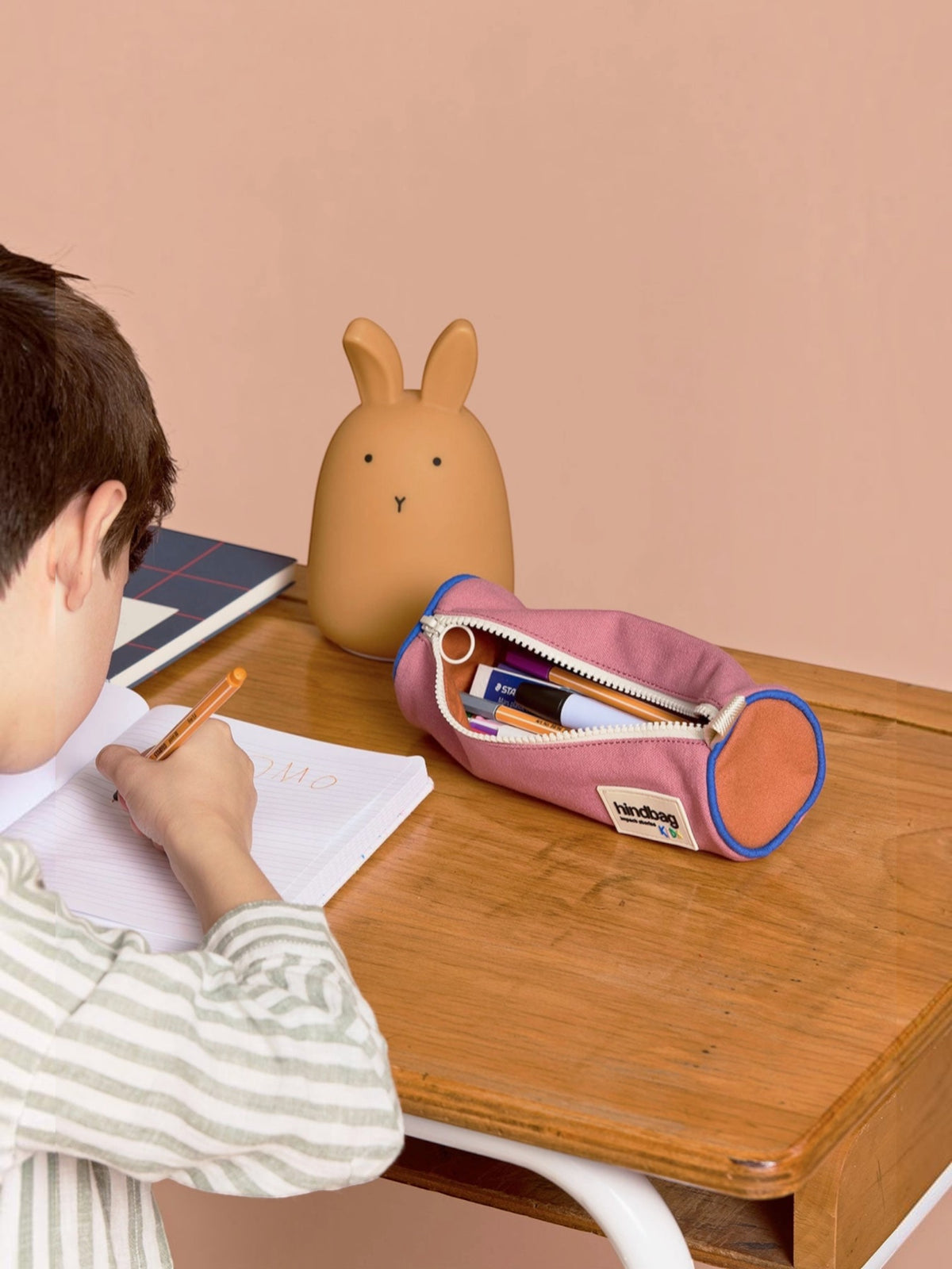 BROCK HINDBAG Mia tricolour pencil case in sage pink and blue on a wooden desk with a child writing