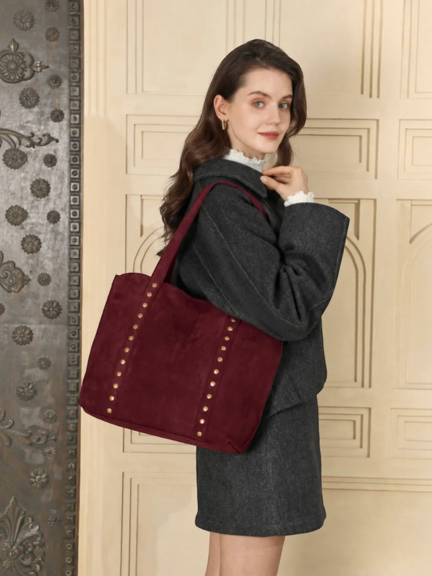 Cabas BROCK INES DELAURE bordeaux en similicuir avec clous décoratifs porté à l'épaule par une femme
