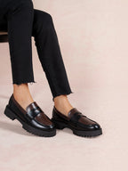 BROCK LADY GLORY two-tone chunky loafers in black and brown faux leather with a thick lug sole worn with black jeans