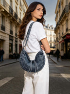 Woman wearing a BROCK LINETA denim-effect crescent crossbody bag with tassel detail on a city street