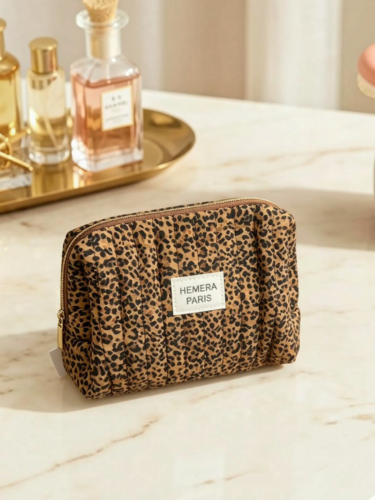 BROCK LINETA quilted cotton makeup bag with a trendy leopard print pattern and a zip closure on a marble surface.