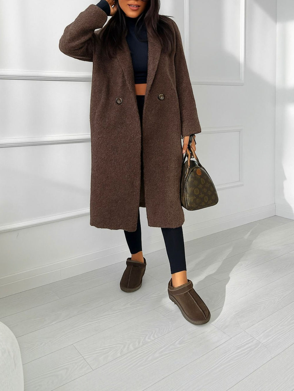 BROCK long brown bouclé coat with double-breasted buttons and side pockets, worn over black leggings