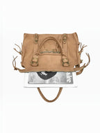 BROCK LOUISA LEE Capucine L vintage tan cowhide leather bag with braided handles, fringe details, and metal studs.