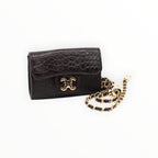 BROCK mini crossbody bag in dark brown faux crocodile leather with a gold chain strap and C.Clo logo emblem.
