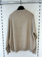 BROCK MISS CHARM beige cotton knit sweater with round neck and long sleeves hanging on a hanger