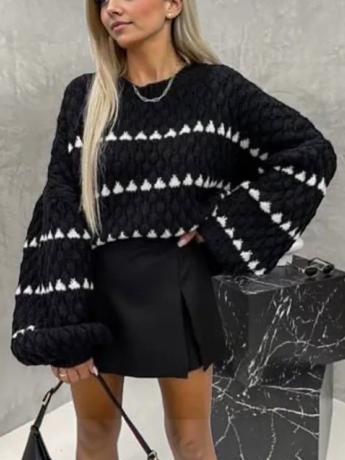BROCK oversize black knit sweater with white triangular striped patterns and round neck worn by a blonde model