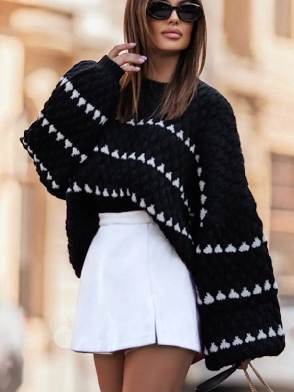 BROCK oversize black knit sweater with white triangular striped patterns worn by a woman with sunglasses