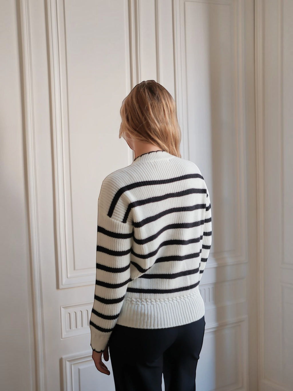 Vue de dos d'une femme portant un pull marinière BROCK en coton blanc à rayures noires avec bordures ondulées