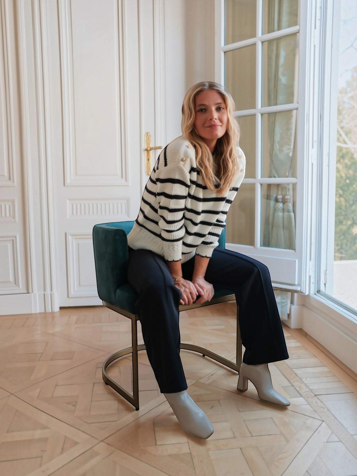 Femme portant un pull marinière BROCK en maille de coton blanc à rayures noires avec boutons dorés aux épaules