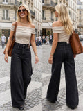 BROCK R.DISPLAY Lyana stretch jeans in black worn by a blonde woman with an off-shoulder top on a city street