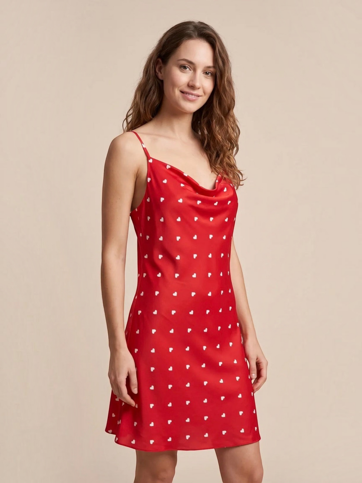 Model wearing a red satin nightie with white heart pattern, cowl neckline, and adjustable straps by BROCK