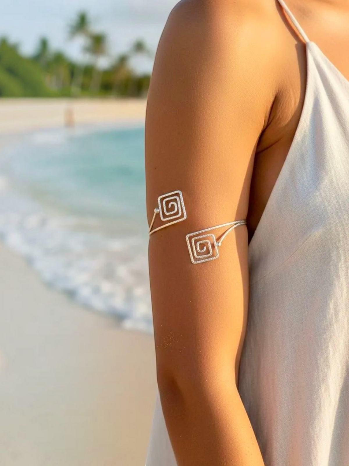BROCK Rosa silver stainless steel armlet bracelet with a minimalist spiral design worn on a beach.