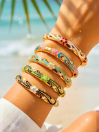 BROCK ROSA Thai-inspired brass bangle bracelets with colorful enamel floral patterns and crystal accents on a wrist