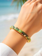 BROCK ROSA Thai-inspired brass bangle featuring green floral enamel detailing and sparkling crystal accents on wrist