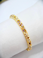 BROCK ROSA Thai-inspired brass bangle bracelet featuring delicate floral enamel patterns and embedded crystals.