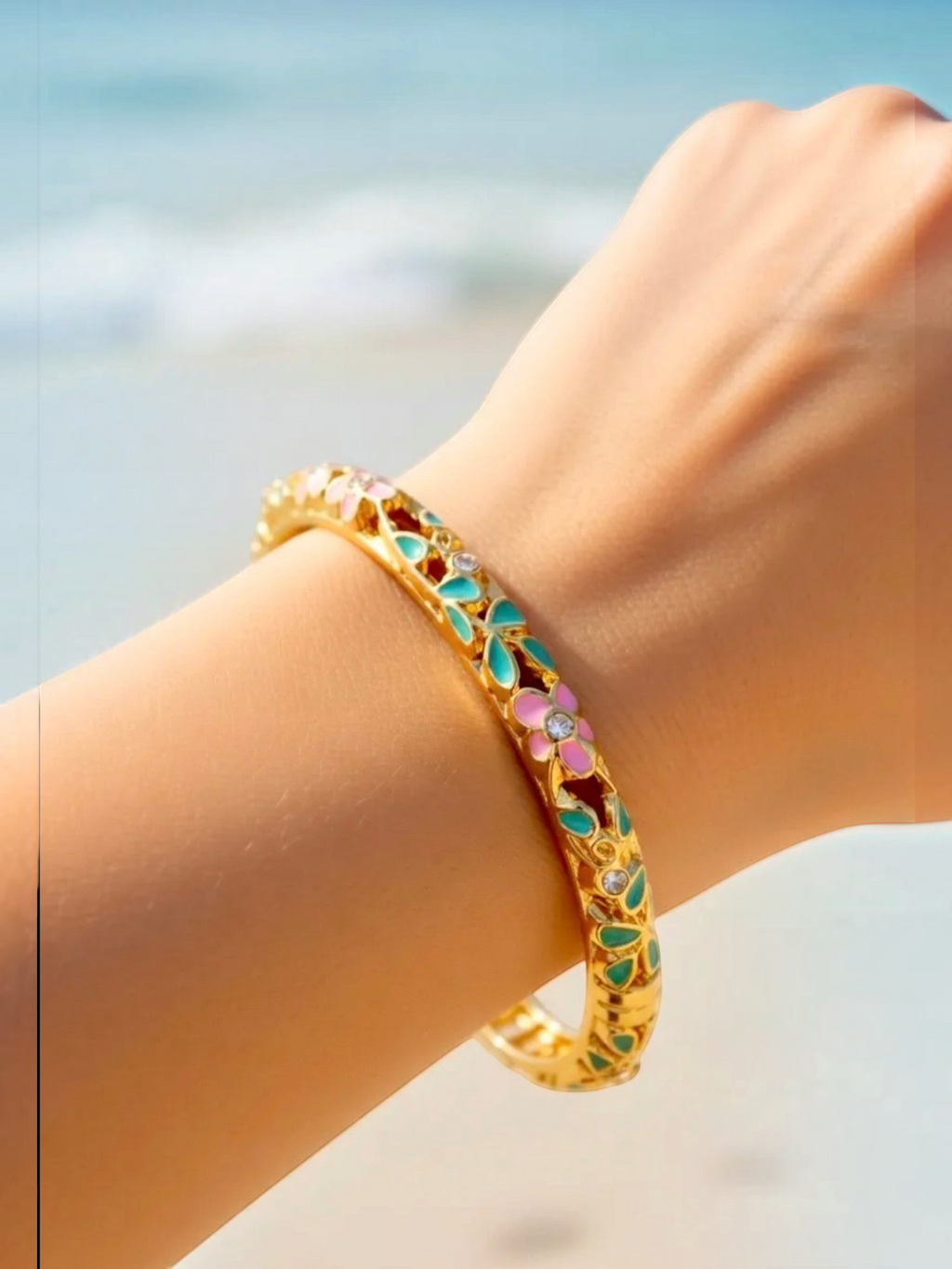 BROCK ROSA Thai-inspired brass bangle bracelet featuring colorful floral enamel details on a woman's wrist.