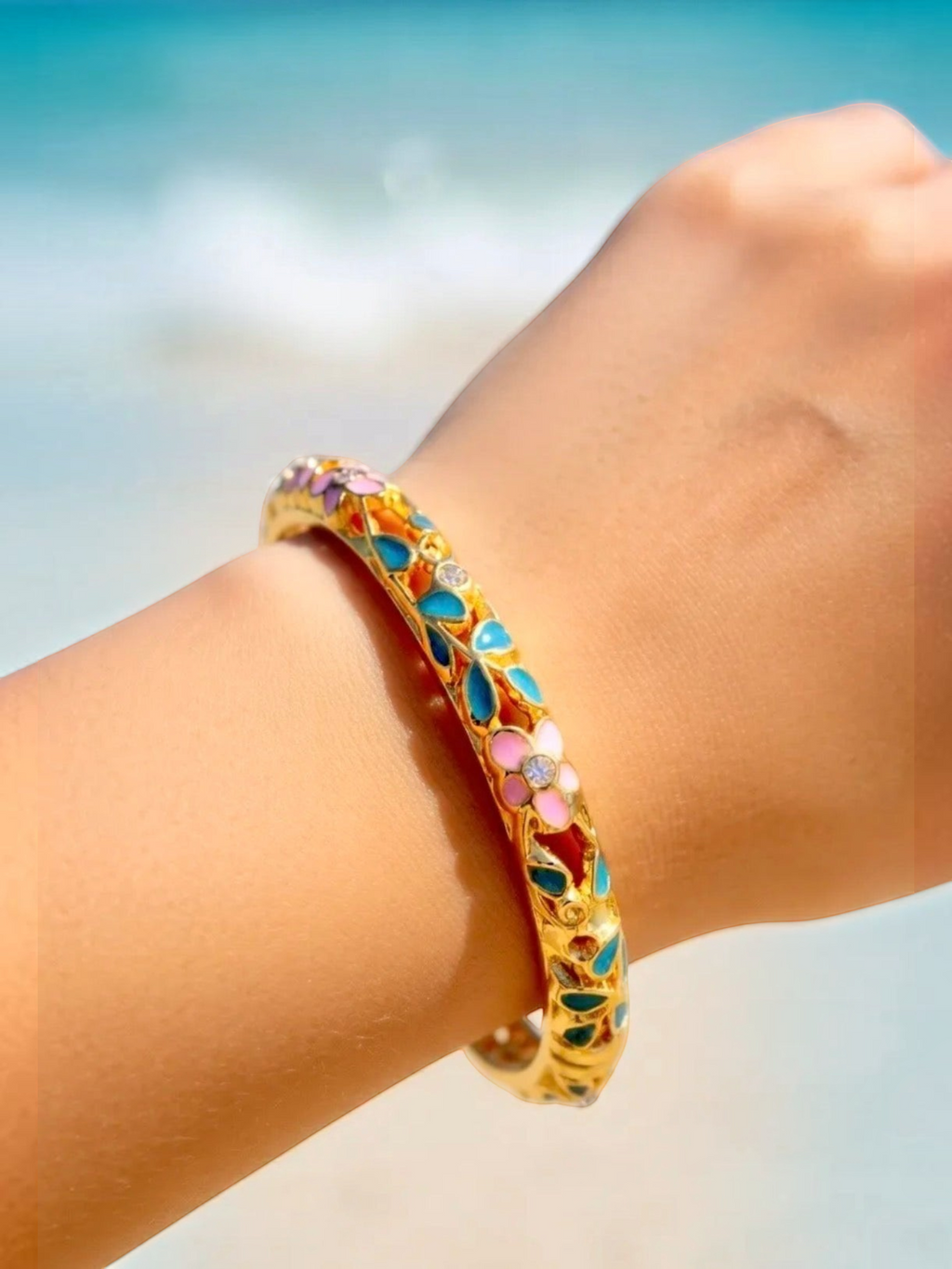 BROCK ROSA Thai-inspired brass bangle bracelet with colorful floral enamel and crystal accents on a wrist