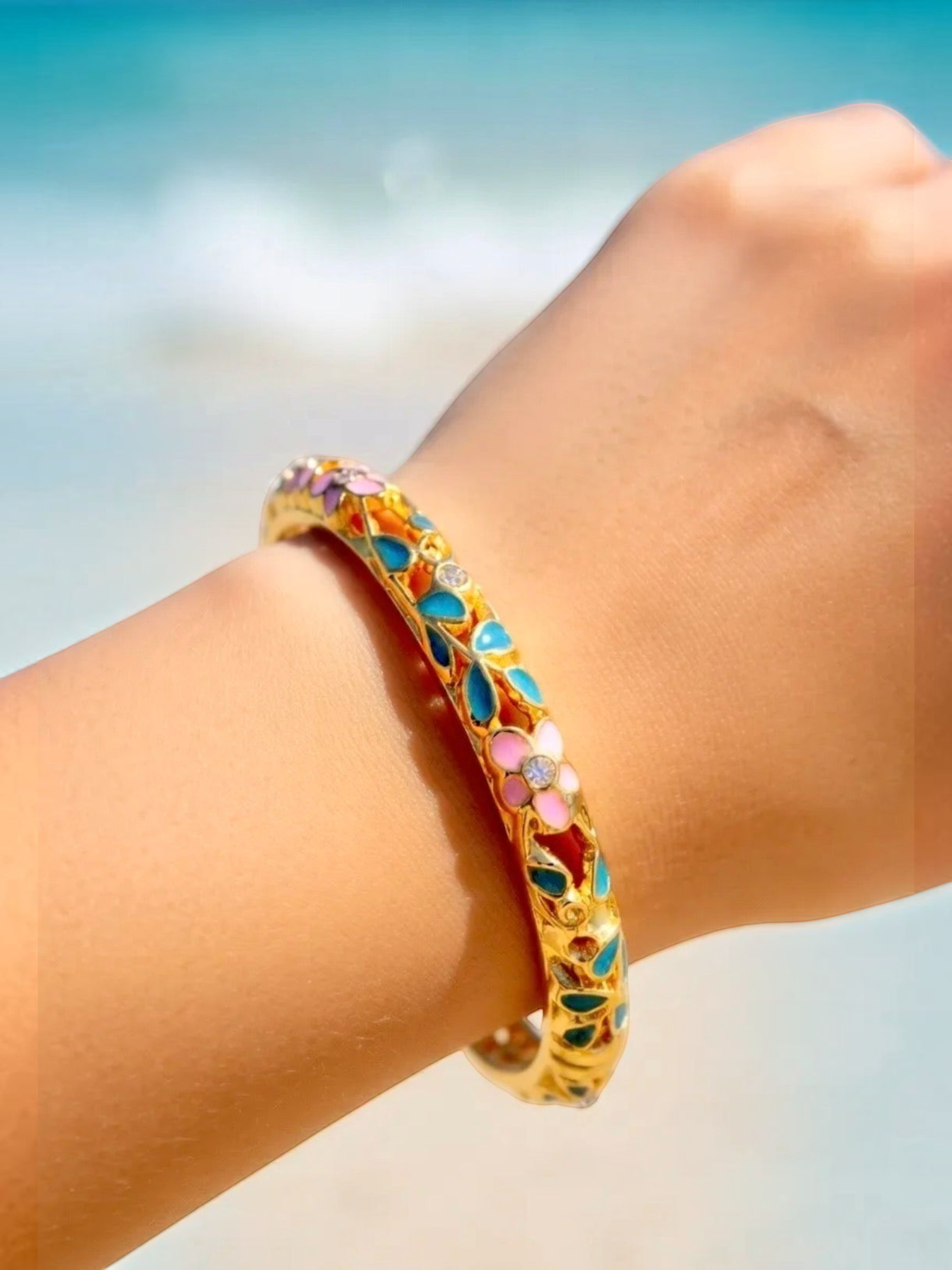 BROCK ROSA Thai-inspired brass bangle bracelet with colorful floral enamel and crystal accents on a wrist