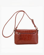 Sac bandoulière marron en PU INES DELAURE de BROCK avec fermeture zippée et rabat, idéal pour un usage quotidien.
