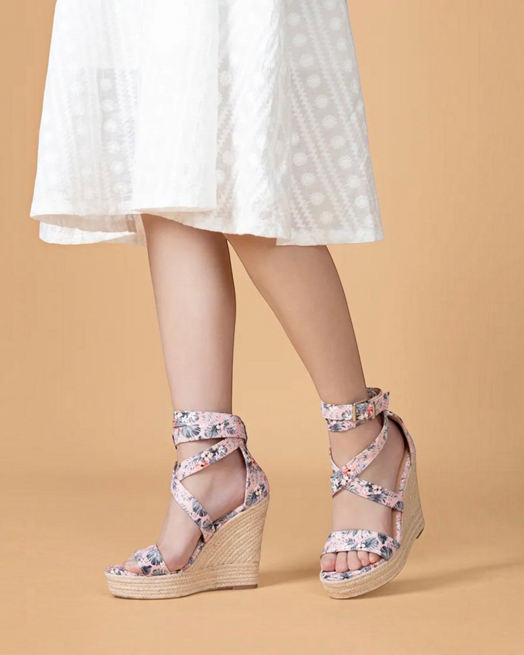 Sandales compensées BROCK à motif floral rose et noir avec semelle en corde tressée portées par une femme