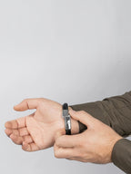 BROCK SERASAR black braided leather bracelet with a silver stainless steel magnetic clasp worn on a man's wrist